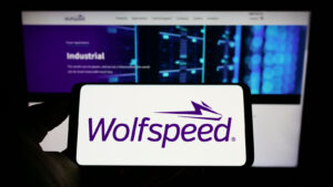 WOLF stock: Person holding smartphone with logo of US semiconductor company Wolfspeed Inc. on screen in front of website. Focus on phone display. Semiconductors Stocks to Sell