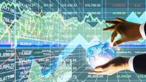 A concept image showing hands holding a globe with stock charts in the background.