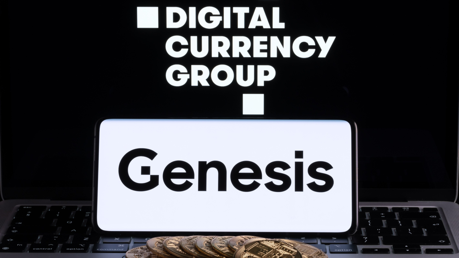 Genesis Global Trading crypto company logo seen on screen of smartphone with bitcoin tokens. Crypto lender owned by Digital Currency Group.