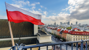 Poland Flag in Blue Sky and the centre of Warsaw in background. EPOL stock