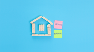 A small house made of wooden blocks and colored sticky notes with the words Mortgage buydowns.