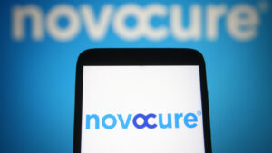 NVCR stock: Novocure limited logo is seen on a mobile phone and a computer screen.