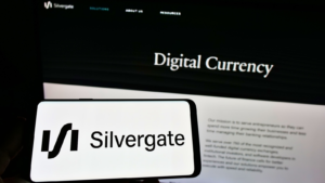 Person holding smartphone with logo of US financial services company Silvergate Bank (SI) on screen in front of website. Focus on phone display. Unmodified photo.