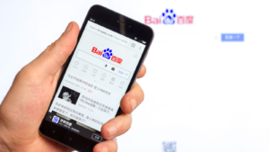 Home page of the popular website Chinese search engine company Baidu (BIDU) on the screen of the Chinese smartphone Xiaomi in the male hand