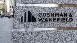 Cushman & Wakefield (CWK) のロゴが入った建物のクローズアップ。