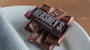 Hershey's milk chocolate pieces on a white plate on top of a wooden table