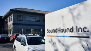 SOUN stock: SoundHound's Headquarters exterior featuring a sign with the company's logo in the foreground and a parking lot and building in the background.