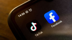 In this photo illustration the icon TikTok and Facebook app seen displayed on a smartphone. Meta stock to buy if TikTok banned.