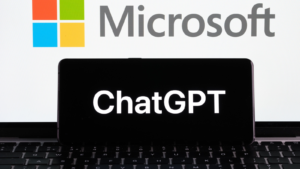 ChatGPT logo visible on smartphone, Microsoft (MSFT) logo visible on laptop.  Microsoft co-pilot