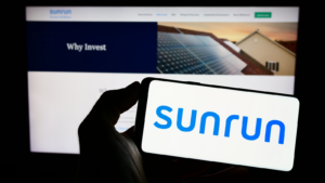 A person holding a mobile phone with the logo of the American company Sunrun Inc.  (RUN) solar energy company on a screen in front of the company's website.  Focus on the phone display.