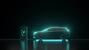 Electric car backlit by cyan blue neon light next to EV charger with cyan blue light and lightning bolt symbol, all against a black background. ev stocks
