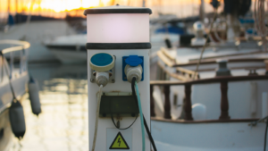Charging station with electrical outlets for yachts in a harbor. Power socket bollard on pier. Marina theme. Charger cables outdoors. A station for boats in boat station Luxury lifestyle travel voyage. FRZA stock