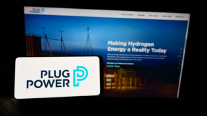 Person holding cellphone with logo of American hydrogen fuel cell company Plug Power Inc on screen in front of web page Focus on phone display