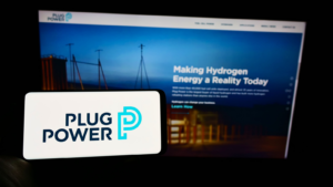 Web ページの前の画面にアメリカの水素燃料電池会社 Plug Power Inc のロゴが入った携帯電話を持っている人、電話のディスプレイに焦点を当てる