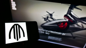 Person holding smartphone with logo of US air taxi company Archer Aviation (ACHR) on screen in front of website. Focus on phone display. Unmodified photo.