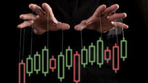 Hands with puppet string and a red and green candlestick stock chart.