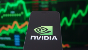 株式市場チャートの背景を持つスマートフォンに表示される Nvidia Corporation (NVDA) のロゴ。 Nvidia は、人工知能ハードウェアの世界的リーダーです。