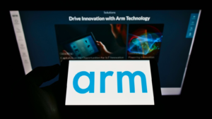 Person holding mobile phone with logo of British semiconductor company Arm Ltd. on screen in front of business webpage. Focus on phone display. Unmodified photo.