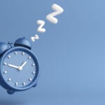 Graphic of blue alarm clock with sleep "Z" shapes coming out of it against blue background, symbolizing sleeper stocks