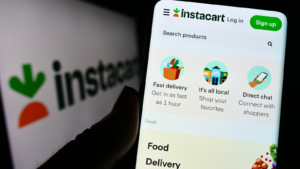 Person holding cellphone with webpage of US retail company Maplebear Inc. (Instacart) on screen with logo. Focus on center of phone display. Unmodified photo. CART stock, Instacart IPO