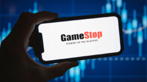 GameStop (GME) logo in front of stock market price graph