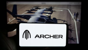 Person holding mobile phone with the logo of the American eVTOL aircraft company Archer Aviation Inc.  (ACHR) on the screen for the web page.  Focus on phone display.  Unaltered photo.