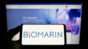 Person holding smartphone with logo of U.S. company BioMarin Pharmaceutical Inc. (BMRN) on screen in front of website. Focus on phone display. Unmodified photo.