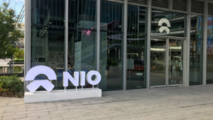 NIO logo and the Nio's user center, NIO House. Retail display of store at downtown LCM mall daytime NIO is a Chinese electric car brand sales person and customers inside