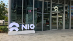 NIO のロゴと Nio のユーザー センター、NIO ハウス。 昼間のダウンタウンの LCM モールの店舗の小売店の展示 NIO は、中国の電気自動車ブランドの販売員と店内の顧客です。 EV株