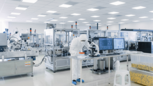 Shot of Sterile Pharmaceutical Manufacturing Laboratory where Scientists in Protective Coverall's Do Research, Quality Control and Work on the Discovery of new Medicine. VRCA stock