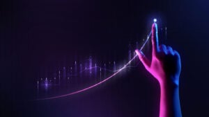 Hand pointing upward next to upward trend stock chart in purple and blackish blue lighting, symbolizes growth stocks