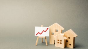 Wooden houses next to chart symbolizing housing market