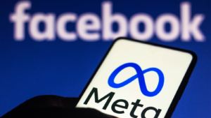 In this photo illustration the Meta logo seen displayed on a smartphone and in the background the Facebook logo