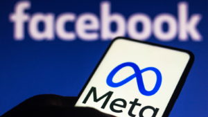 In this photo illustration, the Meta logo is displayed on a smartphone with the Facebook logo in the background