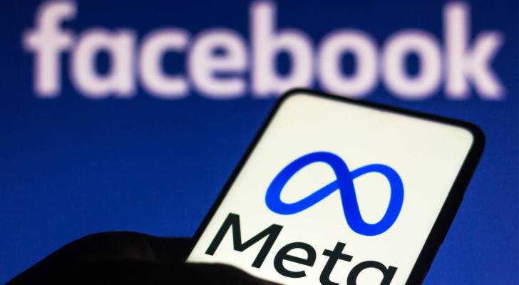 In this photo illustration the Meta logo seen displayed on a smartphone and in the background the Facebook logo