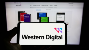 Person holding cellphone with logo of American company Western Digital Corporation (WDC) on screen in front of webpage. Focus on phone display. Unmodified photo. WDC stock