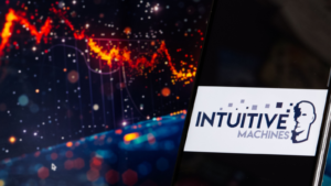 Intuitive Machines logo displayed on a mobile phone, with the abstract background on a computer screen. LUNR stock