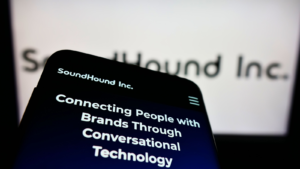 Mobile phone with website of American audio recognition company SoundHound Inc. (SOUN) on screen in front of logo. Focus on top-left of phone display. Unmodified photo.