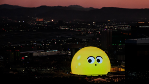  The MSG Sphere illuminated at night with curious cartoon face. SPHR stock