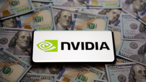 米ドル紙幣の山に置かれたスマートフォンに Nvidia のロゴが見られます。 コンセプト。 選択と集中。 Nvidia などの購入すべき銘柄