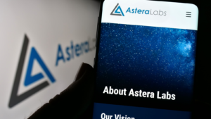 Person holding cellphone with website of US semiconductor company Astera Labs Inc. (ALAB) on screen in front of logo. Focus on center of phone display. Unmodified photo.