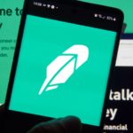 Robinhood (HOOD) app and logo on screen. Robinhood financial services company. The company offers mobile app and website that offers people the ability to invest in stocks