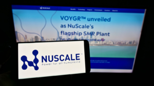 Person holding smartphone with logo of US nuclear power company NuScale Power LLC on screen in front of website. Focus on phone display. Unmodified photo. SMR stock