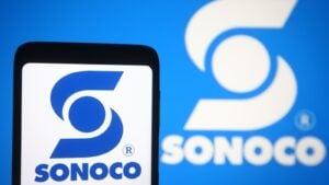 A smartphone showing the logo for Sonoco Products (SON) in front of another version of the company logo.