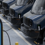 MED shot of fleet modern electric EV delivery vans are being charged in company parking garage. EV stocks
