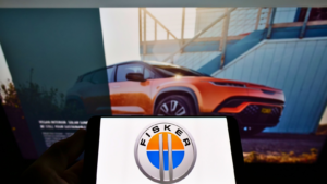 Person holding cellphone with business logo of US electric vehicle manufacturer Fisker Inc. on screen in front of webpage. Focus on phone display. FSRN stock, Fisker stock