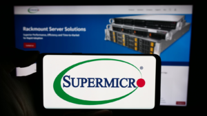 Person holding cellphone with logo of US company Super Micro Computer Inc. (SMCI) (Supermicro) in front of business webpage. Focus on phone display. Unmodified photo.