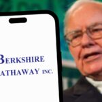 Warren Buffett in the background behind a phone showing the Berkshire Hathaway logo