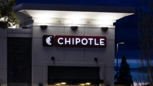 Chipotle Mexican fast food chain restaurant at night. CMG stock