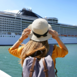 Tourist girl with backpack and hat standing in front of big cruise liner. Cruise stocks